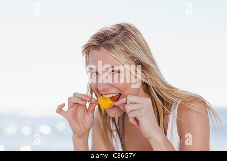 Woman eating popsicle on beach Banque D'Images