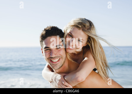 Man carrying girlfriend on beach Banque D'Images