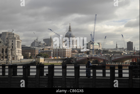 Vue sur la Tamise à partir de la rive sud à la ville et à la Cathédrale St Paul avec la structure de la jetée en premier plan. Banque D'Images