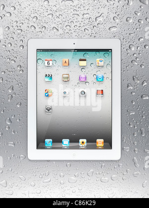 Tablette Apple iPad 2 blanc ordinateur avec des icônes du bureau sur son affichage sur fond d'acier gris humide Banque D'Images