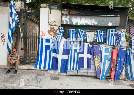 Scène de rue à Plaka, un homme avec des drapeaux grecs pour la vente. Plaka est le vieux quartier historique d'Athènes, Grèce. Banque D'Images