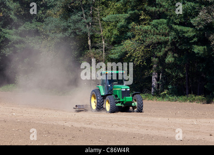 Un tracteur John Deere vert travaillant dans un terrain poussiéreux. Banque D'Images