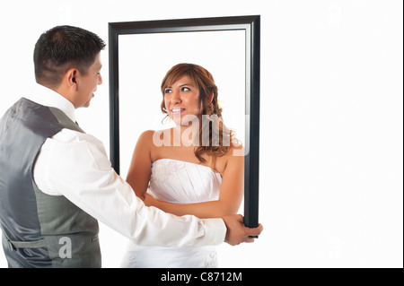 Hispanic Bride and Groom posing avec cadre Banque D'Images