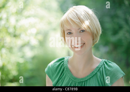 Allemagne, Bavière, Schaeftlarn, Close up of young woman in park, smiling, portrait Banque D'Images