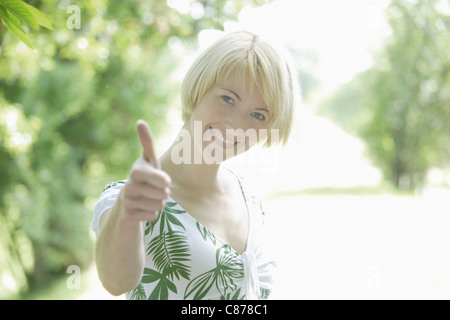 Allemagne, Bavière, Schaeftlarn, Close up of young woman showing her Thumbs up, smiling, portrait Banque D'Images