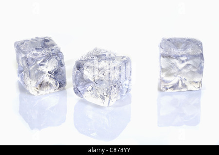 Trois cubes de glace avec la réflexion sur le verre Banque D'Images