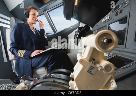 Germany, Bavaria, Munich, Woman flight captain airplane cockpit Banque D'Images