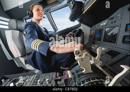 Germany, Bavaria, Munich, Woman flight captain airplane cockpit Banque D'Images