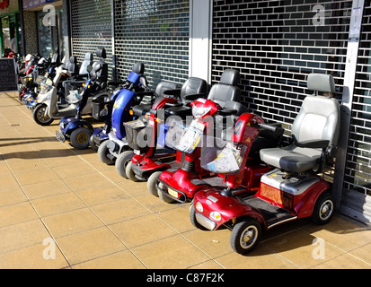 Les scooters de mobilité alignés à l'extérieur d'une boutique dans le marché de Basildon Banque D'Images