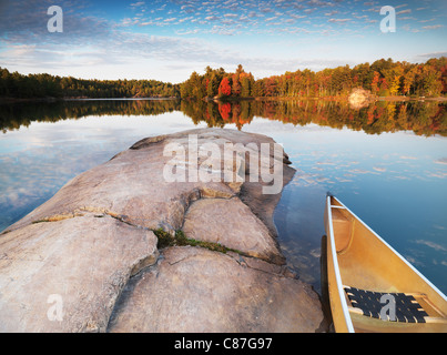 Canot à un rivage rocheux du lac George. Magnifique coucher de soleil automne nature paysage. Le Parc provincial Killarney, l'Ontario, Canada. Banque D'Images