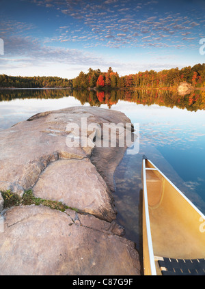 Canot à un rivage rocheux du lac George. Magnifique coucher de soleil automne nature paysage. Le Parc provincial Killarney, l'Ontario, Canada. Banque D'Images