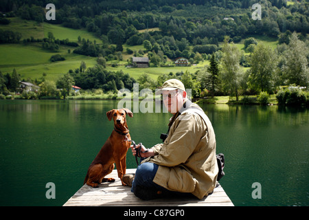 L'homme avec son chien à l'Brennsee, Feld am See, Autriche Banque D'Images