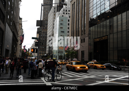 Cyclistes, piétons, taxis jaunes, traversée de la route West 56th Street, 5th Avenue vers Trump Tower et Tiffany & Co, New York Banque D'Images