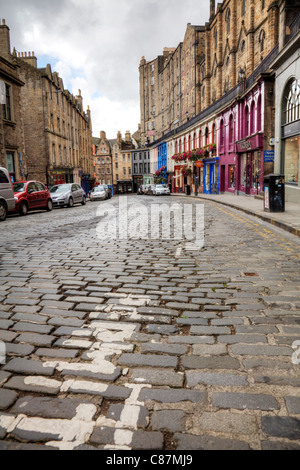 Edimbourg, Ecosse, situé dans la région d'Édimbourg Grassmarket rue sinueuse avec des boutiques haut de gamme sur route pavée Banque D'Images