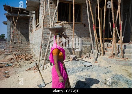 Femme indienne en sari portant en travaillant sur du ciment au site de construction village Khore au Rajasthan, Inde du Nord Banque D'Images