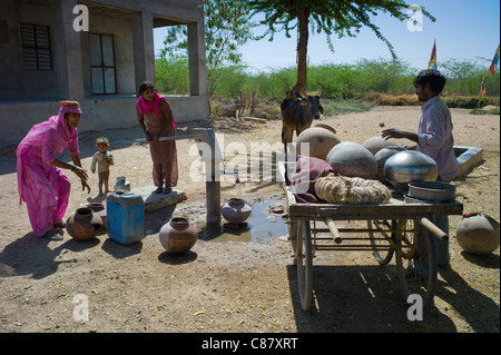 Les femmes indiennes en sari à aller chercher de l'eau pot de bien à Jawali village de Rajasthan, Inde du Nord Banque D'Images