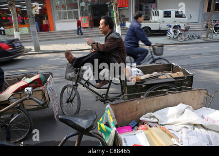 Le recyclage dans les rues de Hangzhou, Chine. Les travailleurs migrants itinérants de prendre une pause de la collecte des déchets d'emballage Banque D'Images