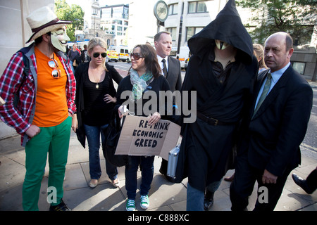 Julian Assange de WikiLeaks à la manifestation Occupy London 15 octobre 2011. Vu ici, il essaie de passer à travers les lignes de police portant une cape noire, le capot et le masque. Il a immédiatement demandé de retirer le masque où il a été traîné dans sur, interrogé et relâché. Banque D'Images