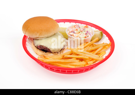 Grillades de cheeseburger avec frites ou chips, salade de choux et un cornichon dans un panier rétro rouge sur fond blanc, découpe. États-unis d'Amérique Banque D'Images