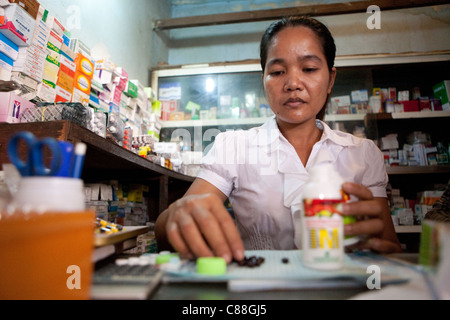 Un pharmacien remplit des ordonnances dans Phaav (Ph'av) Le Cambodge, l'Asie du Sud-Est. Banque D'Images