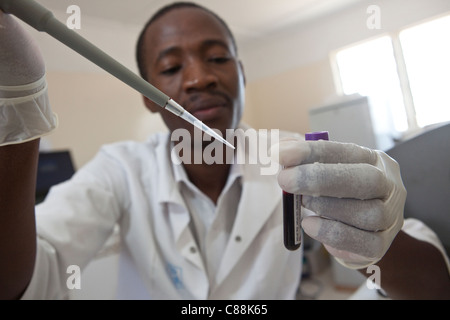 Un des techniciens de laboratoire des échantillons de sang d'essai des patients atteints du VIH dans un hôpital de Luanshya, Zambie. Banque D'Images