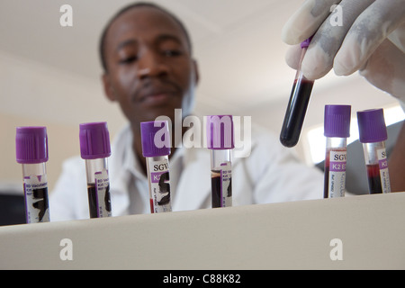 Un des techniciens de laboratoire des échantillons de sang d'essai des patients atteints du VIH dans un hôpital de Luanshya, Zambie. Banque D'Images