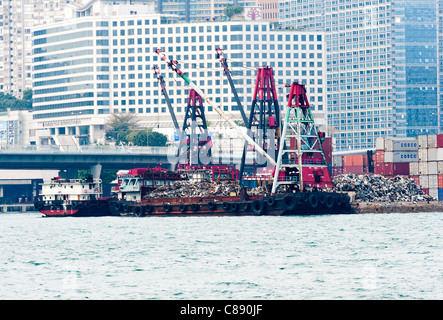 Le traitement de la ferraille sur la jetée avec chaland Barge avec grande grue à Victoria Harbour Kowloon Hong Kong Chine Asie Banque D'Images