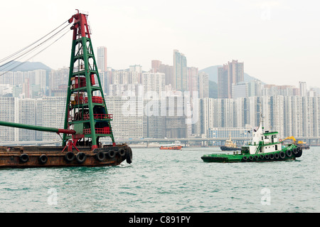 Refuser le recyclage avec grue Barge remorqué par un remorqueur à Kowloon Bay Victoria Harbour Hong Kong Chine Asie Banque D'Images