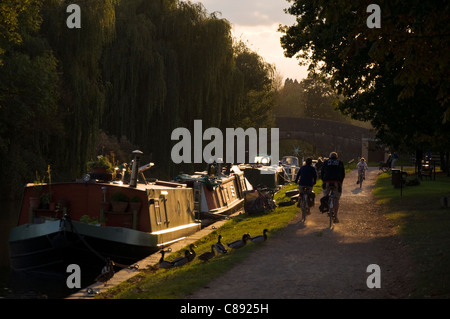 Randonnée à vélo le long du chemin de halage par Kennet and Avon Canal à Bathampton dans lumière du soir Banque D'Images