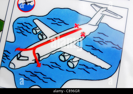 Libre d'une compagnie aérienne carte de sécurité montrant comment évacuer en cas d'atterrissage d'urgence sur l'eau dans un avion Dash 8 Banque D'Images