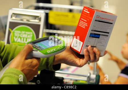 À l'aide d'un client de supermarché Waitrose auto vérification rapide scanner. Banque D'Images