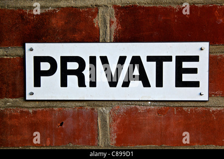 Un panneau qui dit "privées" attaché à un mur de brique fine Banque D'Images