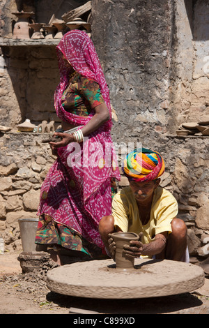 Potter indien en turban Rajasthani travaille avec la famille à la maison faire des pots d'argile dans village de Nimaj, Rajasthan, Inde Banque D'Images