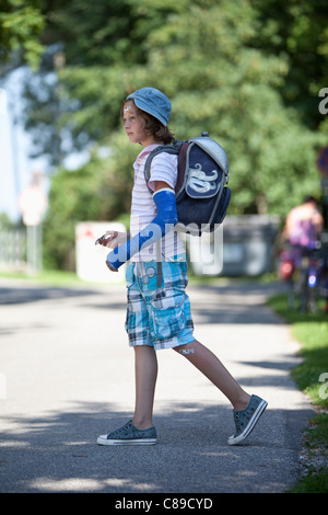 Germany, Bavaria, blessés girl avec le bras dans le plâtre sur chemin de l'école Banque D'Images
