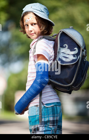 Germany, Bavaria, blessés girl avec le bras dans le plâtre sur chemin de l'école Banque D'Images