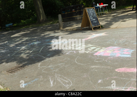 L'enfant dessin à la craie sur la chaussée ou un chemin dans une aire de stationnement Banque D'Images