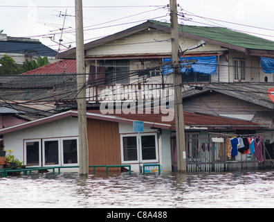 Maisons inondées le long d'un canal à Bangkok pendant la saison de la mousson. Banque D'Images