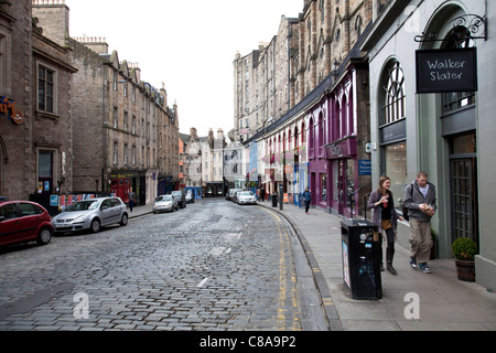 Edimbourg, Ecosse, situé dans la région d'Édimbourg Grassmarket rue sinueuse avec des boutiques haut de gamme sur route pavée Banque D'Images