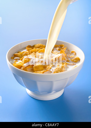 Verser le lait dans un bol de cornflakes Banque D'Images