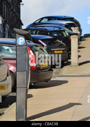 Parking meter et des voitures sur une colline à Glasgow, Écosse, Royaume-Uni Banque D'Images