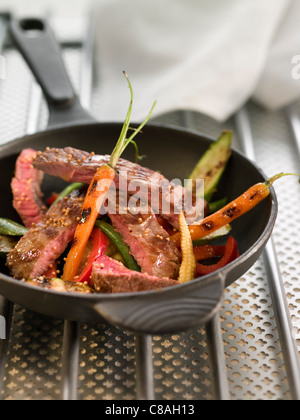 Émincé de veau steak avec de jeunes légumes et graines de moutarde Banque D'Images