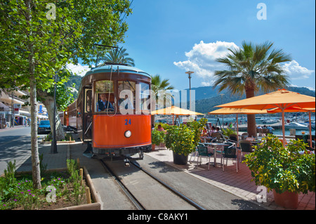 TRAMWAY PORT DE SOLLER tramway traditionnel historique passant devant un café en bord de mer, transportant des passagers de la ville de Soller à Puerto de Soller Mallorca, Espagne Banque D'Images