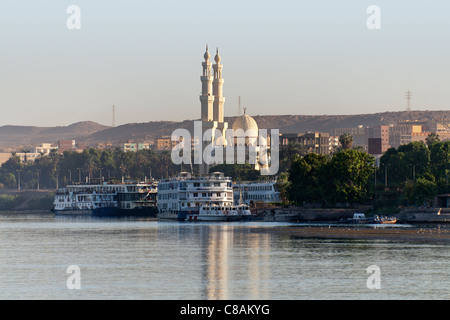 Grande mosquée sur les rives du Nil à Assouan avec deux minarets reflète dans l'eau, et les bateaux de croisière amarrés devant Banque D'Images