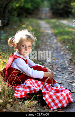 Jolie petite fille dans les bois avec un panier pour les champignons Banque D'Images