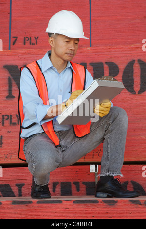 Warehouse Manager writing on clipboard Banque D'Images