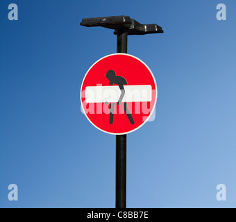 Pas d'entrée d'un signal routier qui a été modifié de façon artistique avec une personne essayant de soulever la barre blanche. Shoreditch, London. UK. Banque D'Images