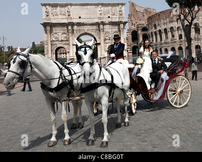 Nouvellement mariés mariage italien blanc à Landau dessiné par chevaux blancs à Rome Colisée montrant l'aspect du sud Arc de Constantin Banque D'Images