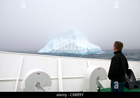 Tourisme un homme debout sur le pont du navire MV l'expédition Antarctique Ushuaia en regardant un iceberg dans l'Océan Austral Banque D'Images