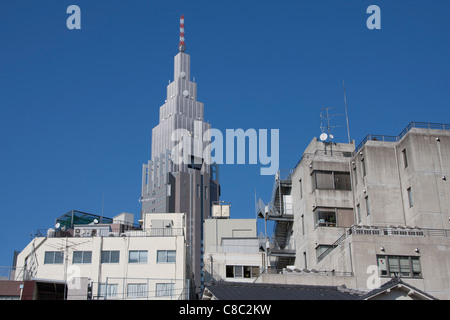 La tour de télécommunications Docomo distinctif au-dessus des maisons et des bureaux à Shinjuku, Tokyo, Japon Banque D'Images