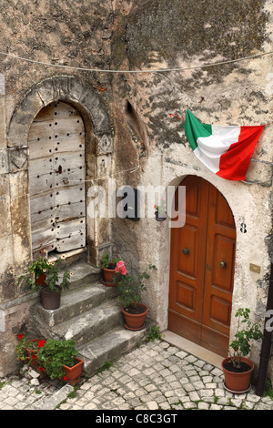 Le drapeau italien vole au-dessus d'une porte à Santo Stefano de Sessanio dans les Abruzzes, en Italie. Banque D'Images